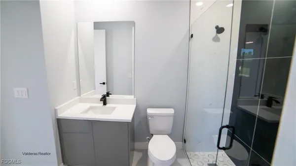 a bathroom with a sink mirror vanity and toilet
