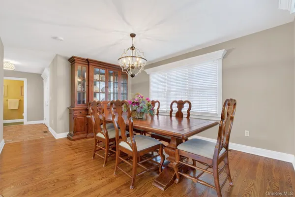 a view of a dining room with furniture a chandelier and wooden floor