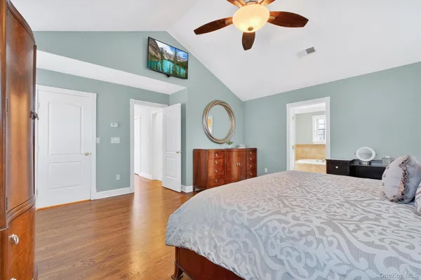 a bedroom with a bed a mirror and a window