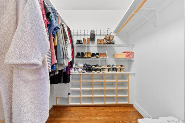 a view of walk in closet with clothes and shoes