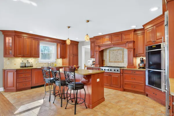 a kitchen with stainless steel appliances granite countertop wooden cabinets a dining table and chairs
