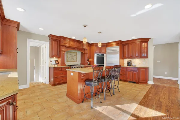 a kitchen with stainless steel appliances kitchen island granite countertop a table and chairs