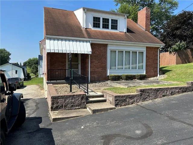 a view of a house with a patio and a yard