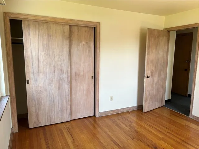 an empty room with wooden floor and a window