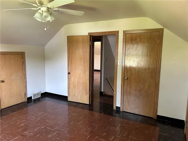 an empty room with closet and a chandelier fan
