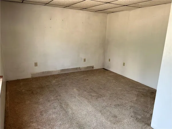 an empty room with a window and closet area
