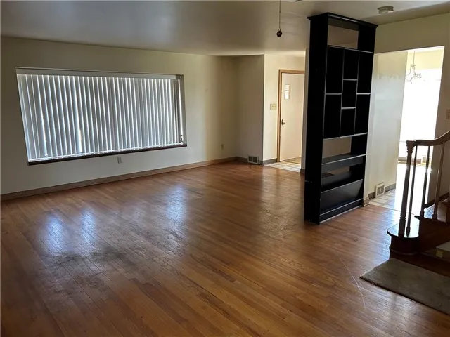 an empty room with wooden floor and closet
