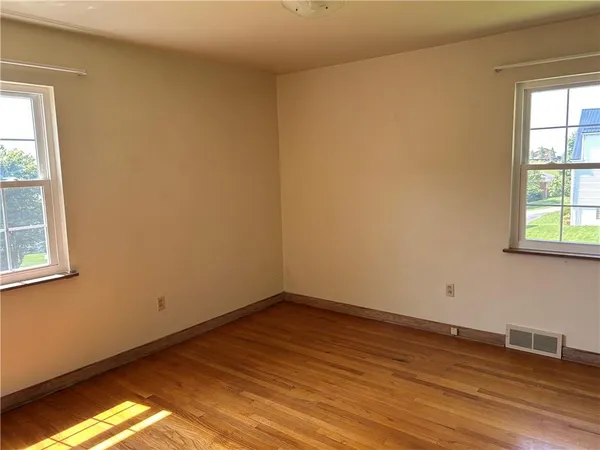 a view of a room with wooden floor and windows