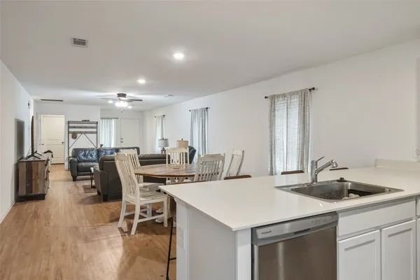 a kitchen with a sink stainless steel appliances and white cabinets