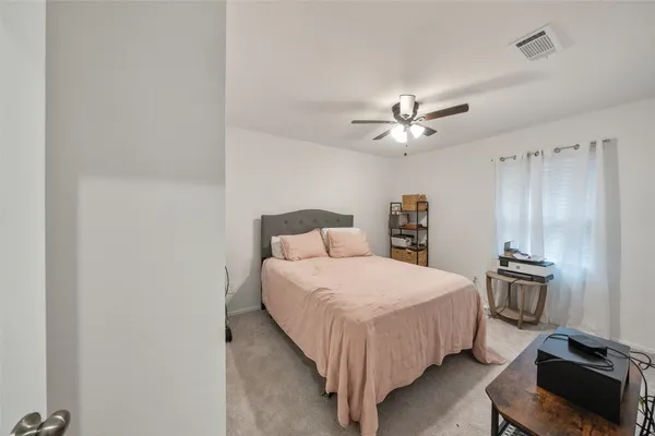 a bedroom with a bed and a ceiling fan