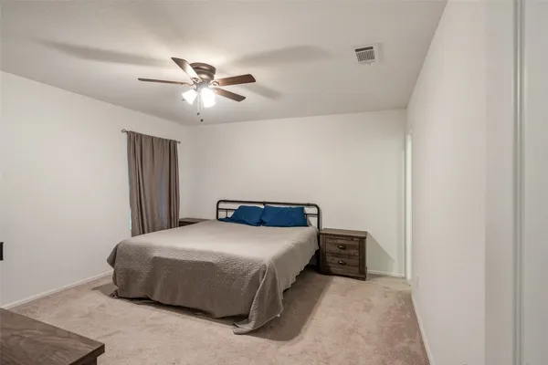 a spacious bedroom with a bed and a couch