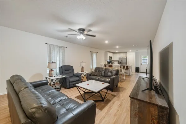 a living room with furniture a ceiling fan and a rug