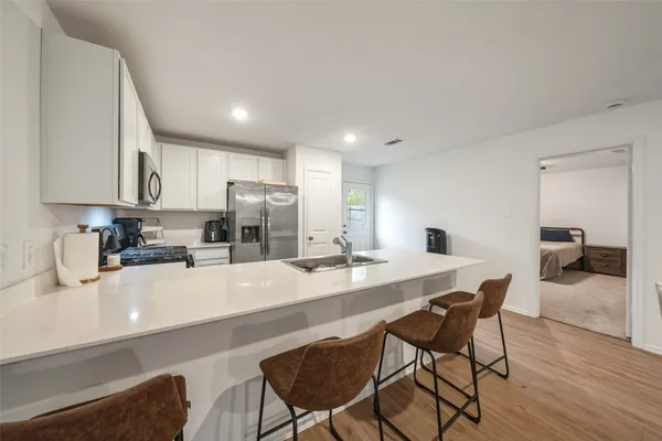 a kitchen with a dining table chairs and wooden floor