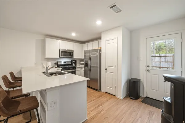 a kitchen with refrigerator cabinets and wooden floor