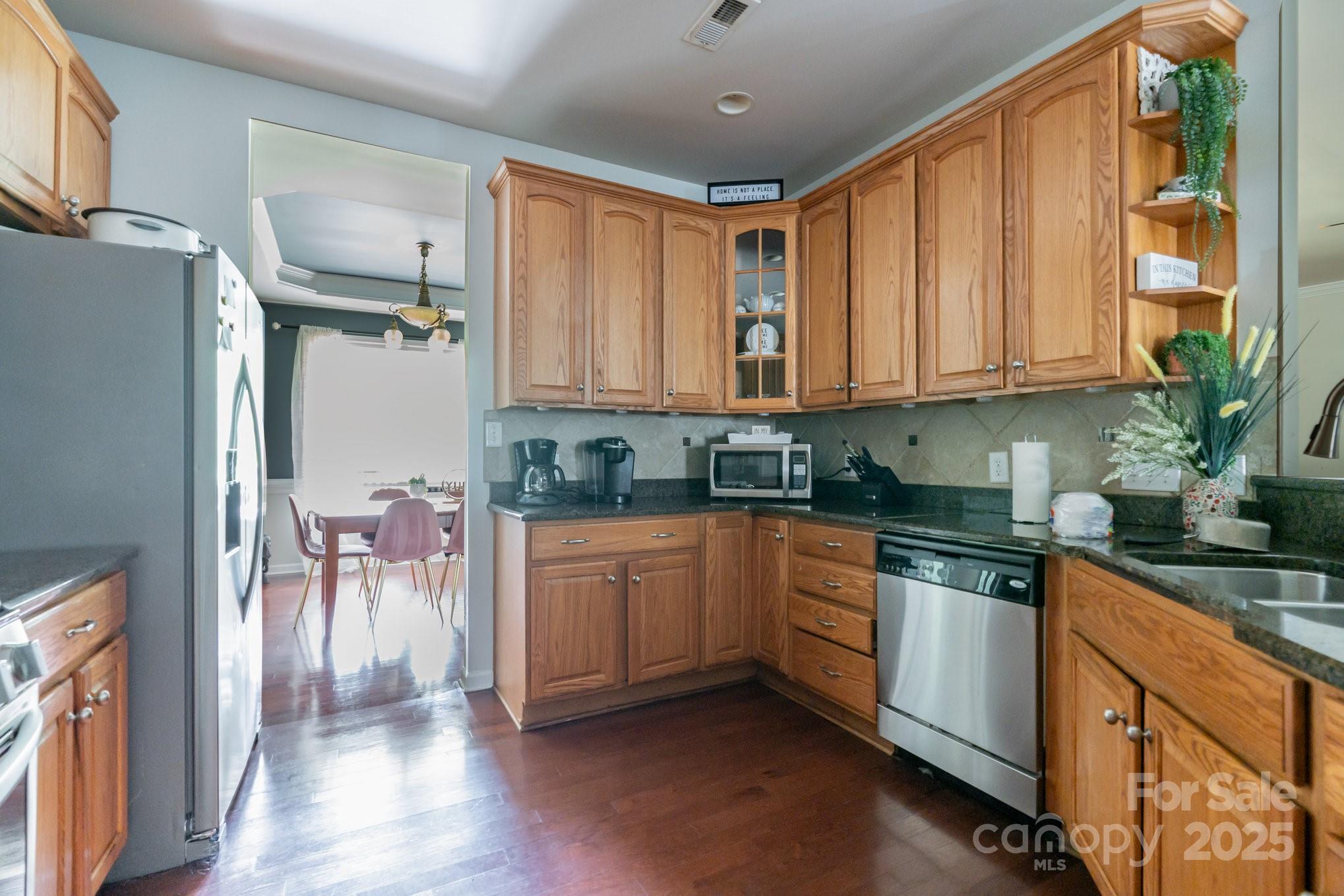 306 Nance Road Charlotte, NC 28214 - Photo 10 of 40 a kitchen with granite countertop a refrigerator a sink a dining table and chairs