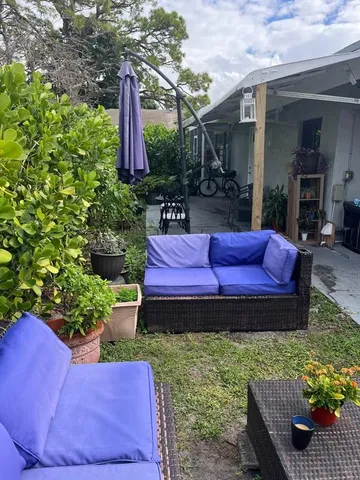 a view of a backyard with table and chairs potted plants