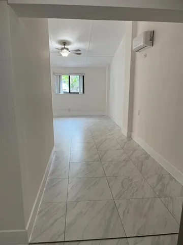 a view of an empty room and window and wooden floor