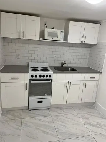 a kitchen with white cabinets and white appliances
