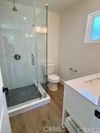 a bathroom with a granite countertop sink a toilet and shower