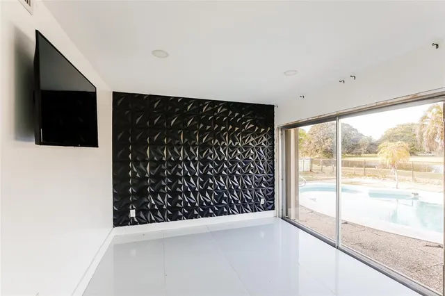 a view of an empty room with wooden floor and windows