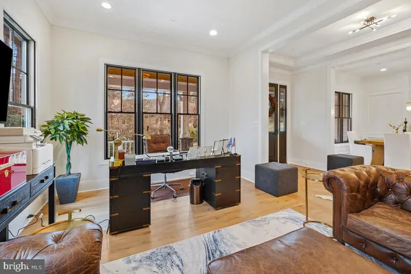 a living room with dining table and a chandelier