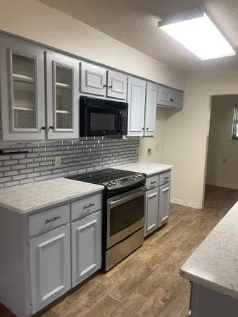 a kitchen with stainless steel appliances granite countertop a stove microwave and sink