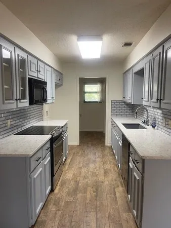 a kitchen with stainless steel appliances granite countertop a sink stove and cabinets