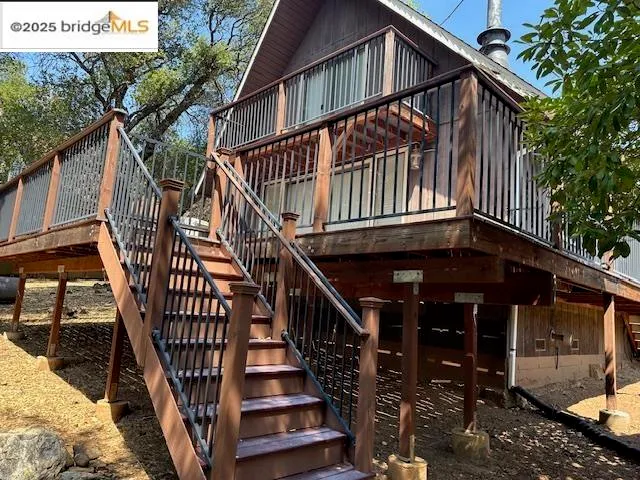 a view of entryway with wooden stairs and a small yard
