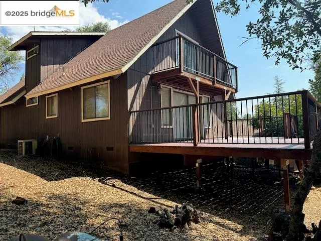 a view of a house with a small yard and wooden fence