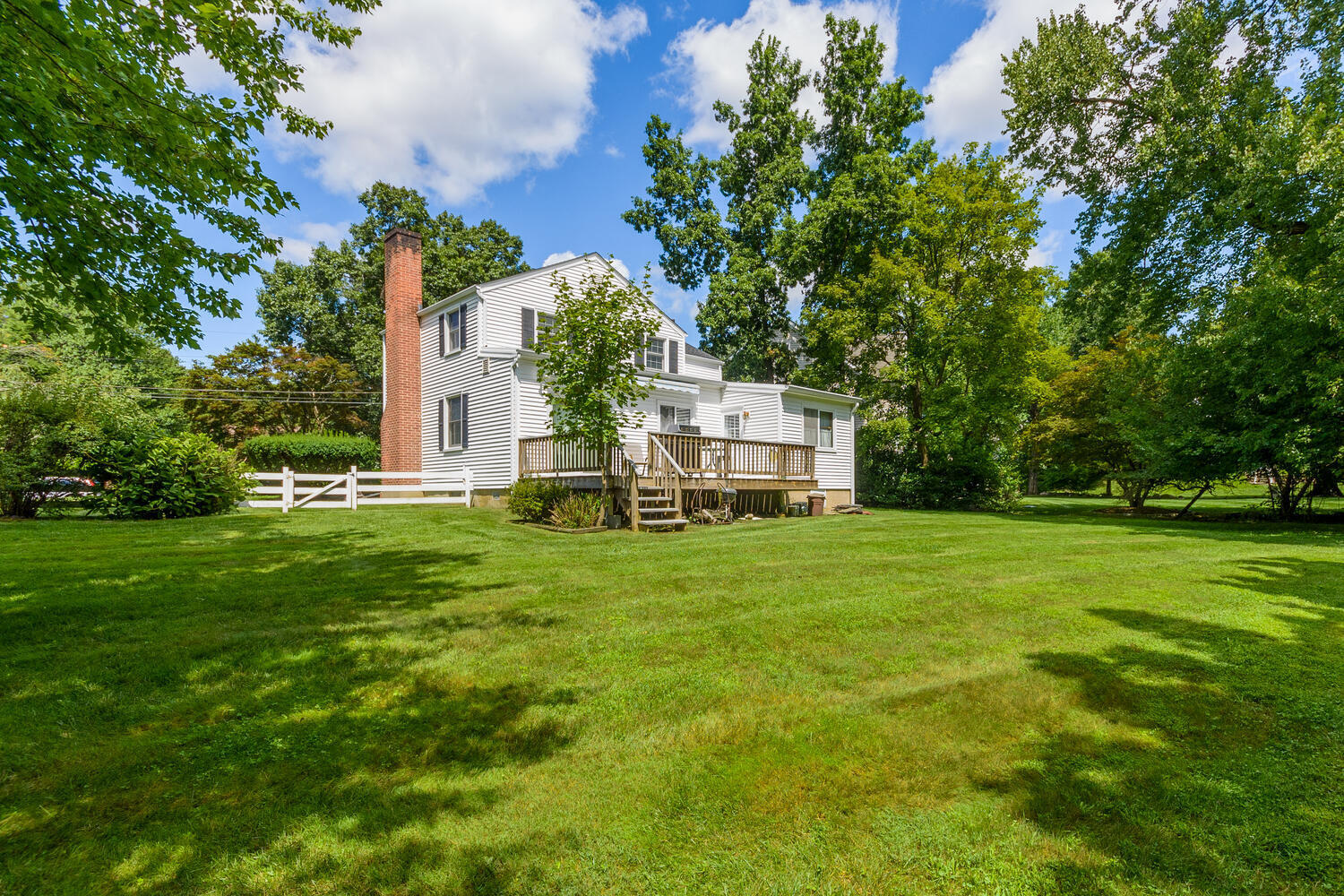 15 Miles Road Darien, CT 06820 - Photo 18 of 23 a view of a house with a big yard potted plants and large trees