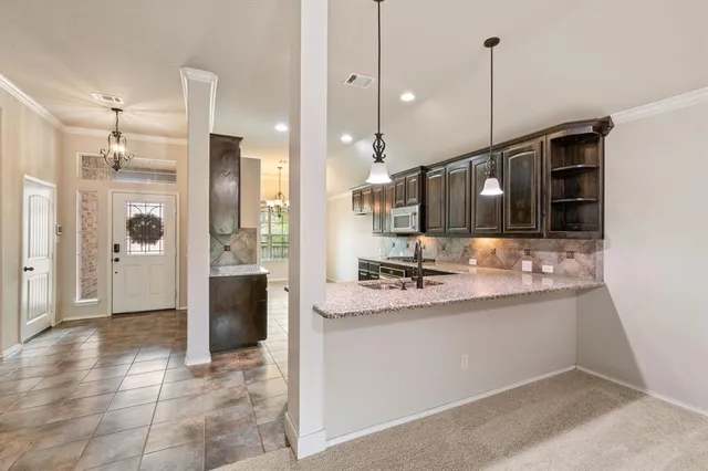 a view of a kitchen with a sink and refrigerator