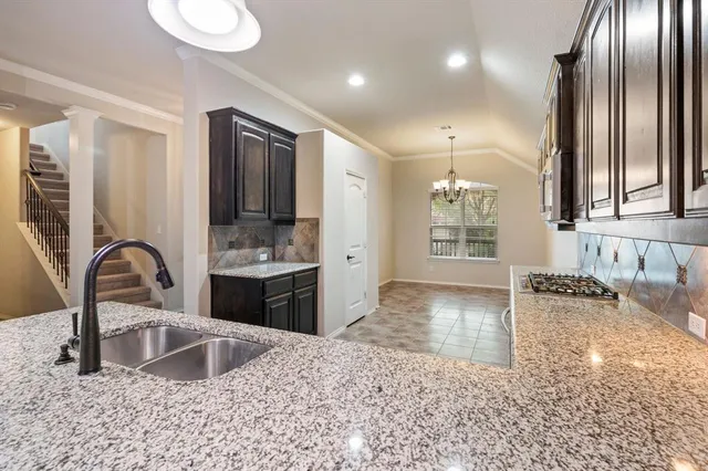 a large kitchen with granite countertop a sink stainless steel appliances and cabinets