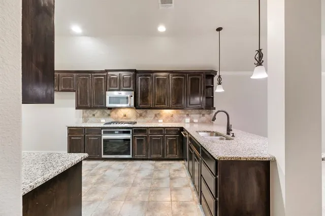 a kitchen with stainless steel appliances granite countertop a sink stove and cabinets