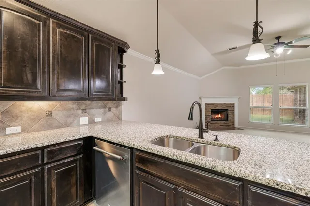 a kitchen with granite countertop stainless steel appliances a sink stove top oven and cabinets