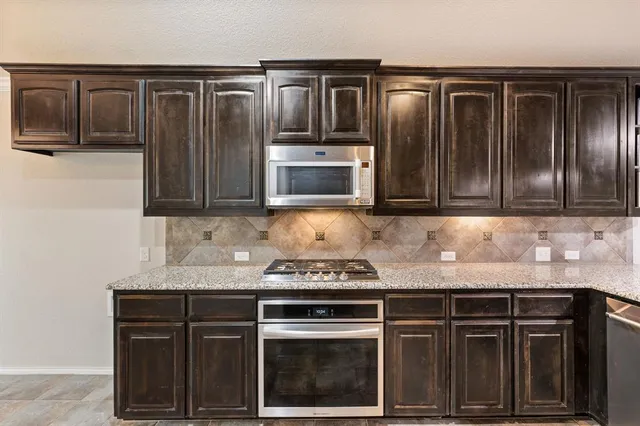 a kitchen with granite countertop stainless steel appliances and cabinets