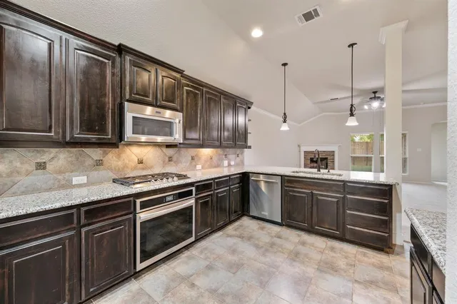a kitchen with stainless steel appliances granite countertop a sink and stove top oven