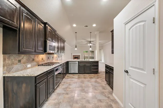 a large kitchen with stainless steel appliances granite countertop a stove a sink and a refrigerator