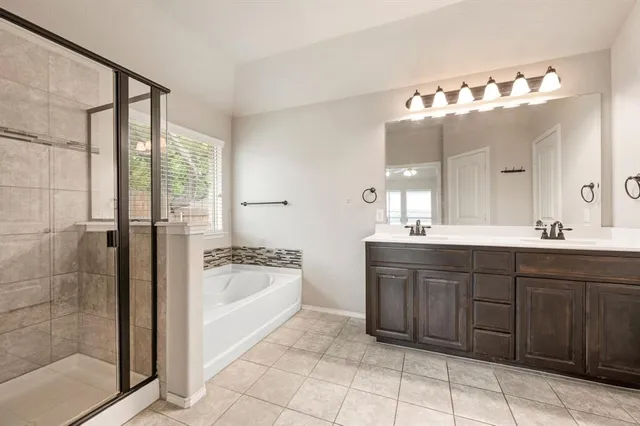 a spacious bathroom with a tub sink and mirror