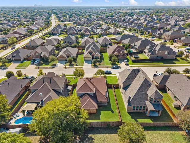 an aerial view of residential houses with outdoor space and swimming pool