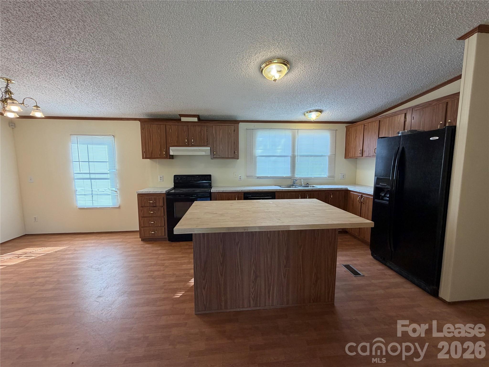 7141 Lingerfelt Road Vale, NC 28168 - Photo 9 of 25 a kitchen with kitchen island a refrigerator wooden floor and a window