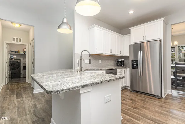 a kitchen with white cabinets and appliances