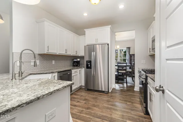 a kitchen with white cabinets and white appliances