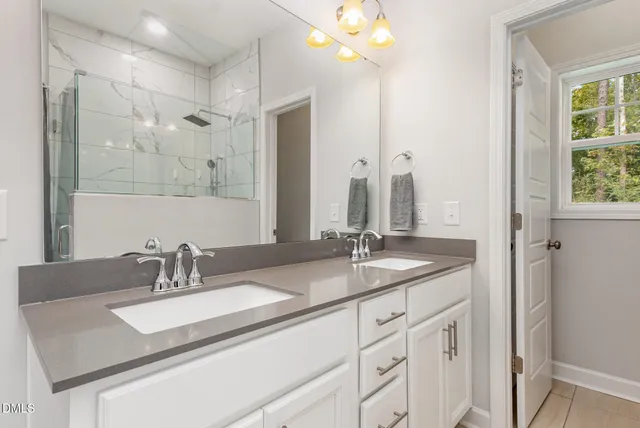 a bathroom with a double sink shower and a mirror