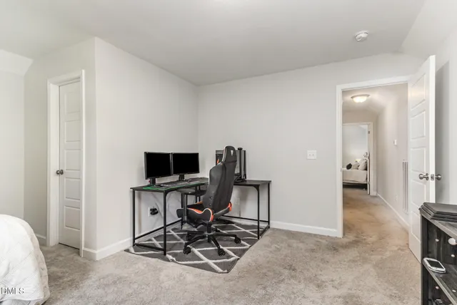 a bedroom with a bed and a computer on a desk