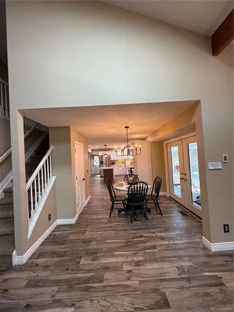 a dining room with furniture and a floor to ceiling window