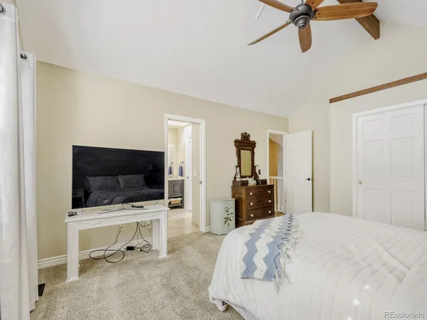 a bedroom with a bed and a flat tv screen on wall