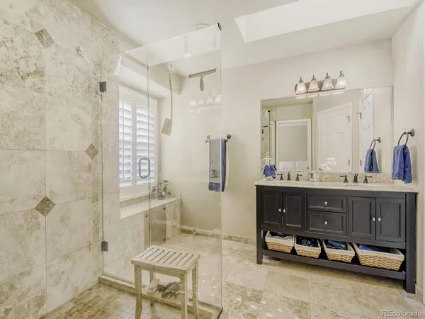 a spacious bathroom with a double vanity sink toilet and shower