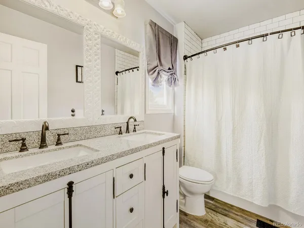 a bathroom with a granite countertop sink toilet and a mirror
