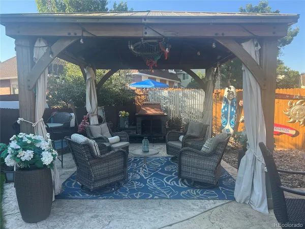 a view of a patio with dining table and chairs under an umbrella