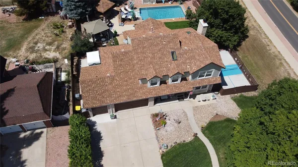 an aerial view of a house with a yard and greenery